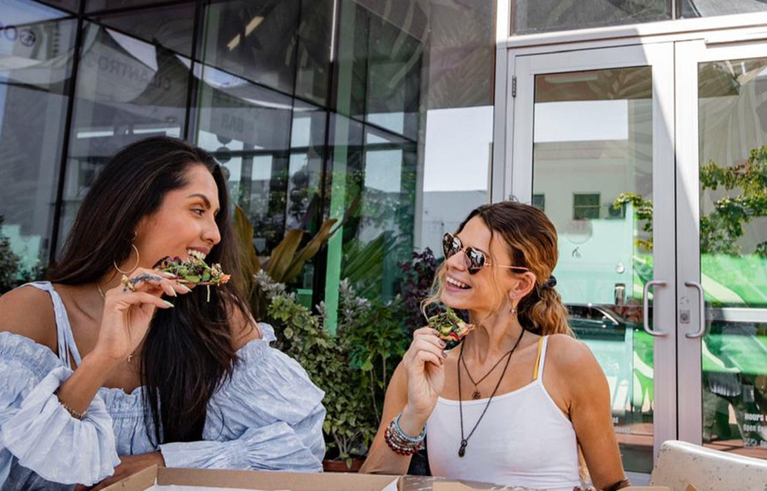 Two women enjoying Pizza at Lincoln Eatery